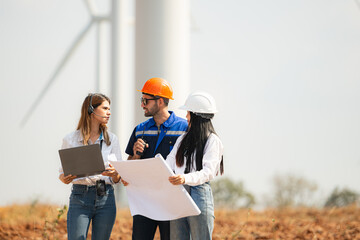 Engineer and Architect working on construction site with wind turbine background.