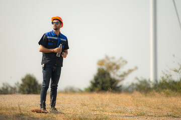 Engineer working in wind turbine farm with blue sky background