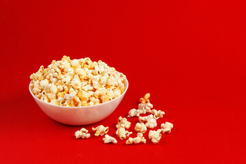 Fototapeta na wymiar plate with popcorn on a red background
