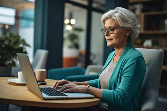 Beautiful Senior Woman Using Laptop Computer While Sitting At Comfortable Chair At Home.