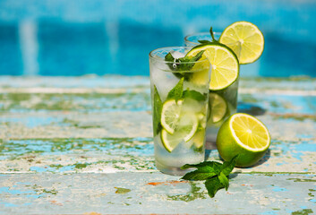 Glasses of homemade lemonade on a rustic wooden background