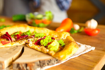 Homemade pizza and vegetables on wooden table