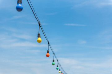 Colorful string lights for party decoration against blue sky