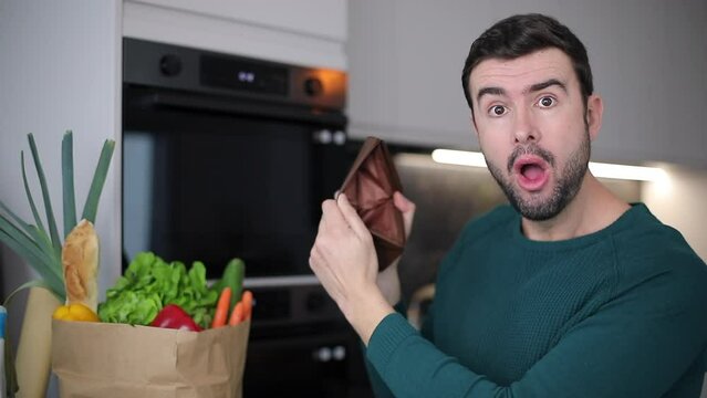 Man showing empty wallet after doing grocery shopping 