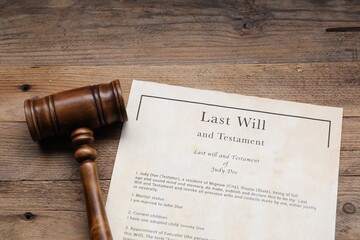 Last Will and Testament with gavel on wooden table, above view