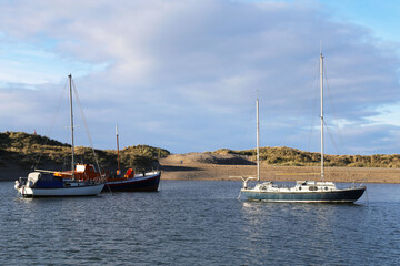 Yachts safely moored behind a sand dune at Barmouth, Gwynedd, Wales, UK. 
