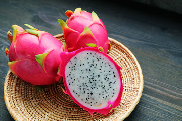 Fresh Ripe Dragon Fruit Cut in Half with Whole Fruits in a Basket 
