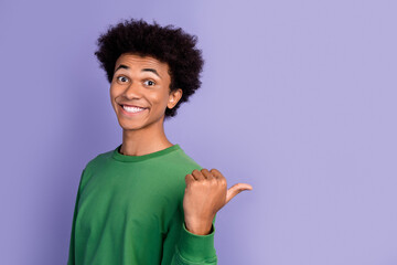 Photo of cheerful cool man dressed green sweater showing thumb back empty space isolated violet color background
