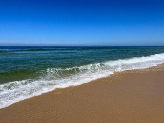 Blue seascape background, clear blue sky and blue sea horizon, sandy coastline