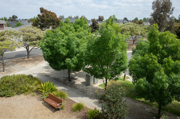 Elevated view of a suburban park with a public bench seat in an Australian neighbourhood with...