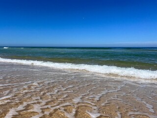 Blue seascape background, clear blue sky and blue sea horizon, sandy coastline