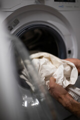 A man doing laundry, washing machine