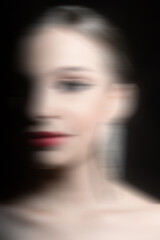 Fototapeta premium Beauty, make-up and fashion concept. Beautiful classic woman studio portrait. Model with classic hairstyle, fancy earrings and red lipstick. Model looking aside. Motion blur effect style