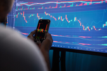 Crypto trader investor broker holding finger using cell phone app executing financial stock trade...