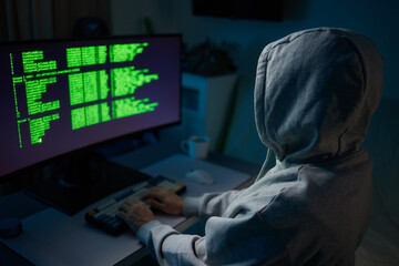 Hacker using the computer. Man in a hoodie breaks the access to steal information and infects computers and systems