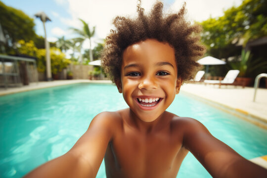 Happy little African American boy taking selfie in an outdoor swimming pool
