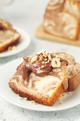 A piece of marble biscuit with chocolate cream and nuts