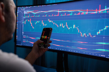 Crypto trader investor broker holding finger using cell phone app executing financial stock trade...