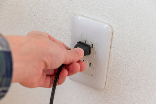 壁のコンセントに差し込まれる電源プラグ