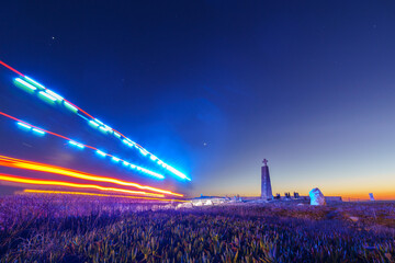 Long exposure of fire truck with blue lights driving to cross on a stone pillar at Cabo da Roca...
