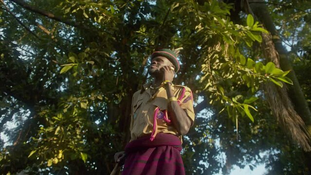 Karamojong Tribal Warrior Talking On The Phone In African Forest In Uganda. low angle shot