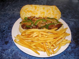 Beef burger with French fries on a white plate on a blue background
