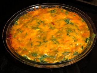 Spinach omelet in a glass bowl on a black background