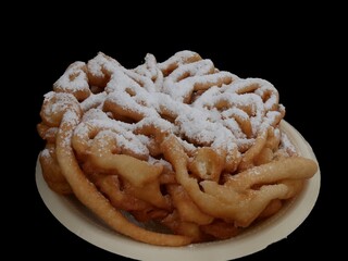 Funnel cake with powdered sugar on a plate, isolated on black background