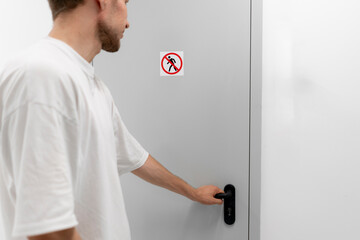 A person is seen opening a door with a clear no entry sign posted, potentially ignoring security...