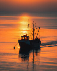 Fototapeta na wymiar Fishing Vessel Against Fiery Sunrise Seascape