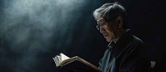 Asian elderly man who reads a book. Copy space image. Place for adding text