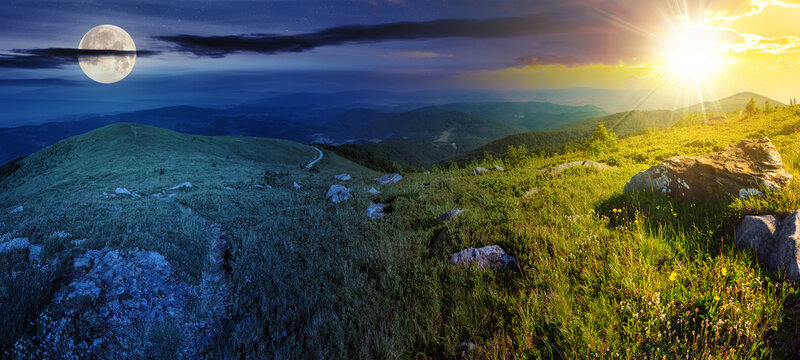 panoramic landscape with narrow meadow path in grass among white stones on top of mountain range with sun and moon at twilight. day and night time change concept