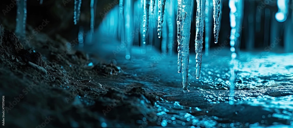 Poster icicles in cold blue light shining in the darkness at night. copy space image. place for adding text