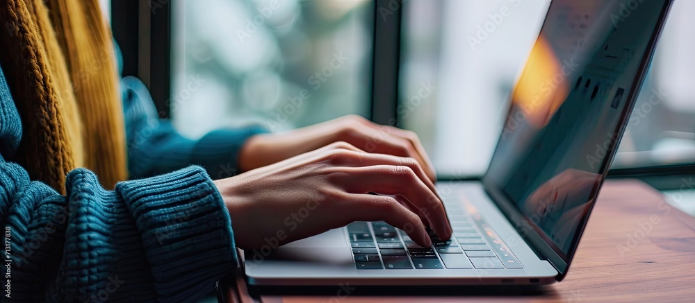 Poster hands typing on laptop checking emails and browsing the internet for creative ideas in office closeu