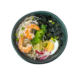 Green bowl of soup with shrimps, sliced radish, lime slice, boiled egg, seaweed and noodles viewed from above.