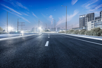 Fototapeta na wymiar New asphalt road and city buildings landscape at night