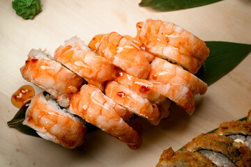 Top view of part of a set of shrimp sushi rolls covered in brown transparent sauce