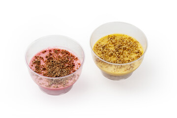 View of pink and yellow desserts of whipped cream topped with grated chocolate isolated on white