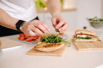 Close-up of man put organic arugula on bruschetta. Vegan food