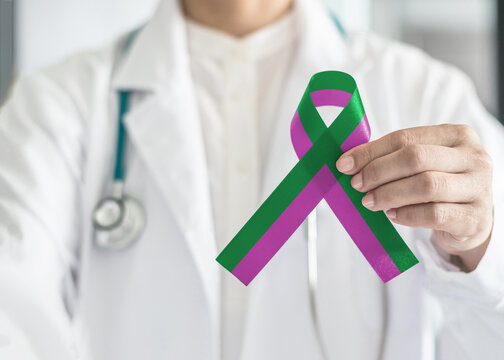 Anal cancer awareness and Stickler Syndrome with green purple ribbon raising awareness on health and illness month with bow color on surgical doctor gown in clinic or hospital - Powered by Adobe