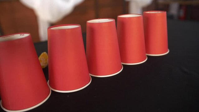 Seamless looping animation of assorted disposable red cups for coffee, tea, hot chocolate or any other beverage. Stacks of paper cups. Set of many cups for a fast-food restaurant, coffee shop, cafe.