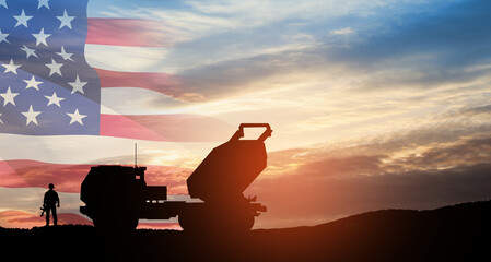 Artillery rocket system are aimed to the sky and soldier at sunset with USA flag. Multiple launch...