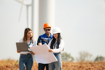 Engineer and Architect working on construction site with wind turbine background.