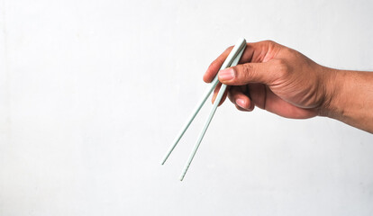 man's hand holding chopsticks isolated white background