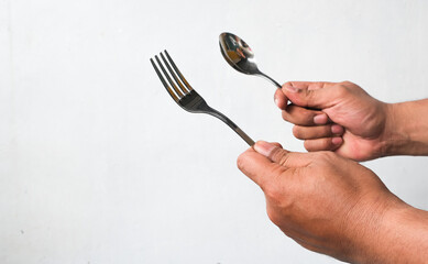 portrait of man's hand holding spoon and fork isolated on white background