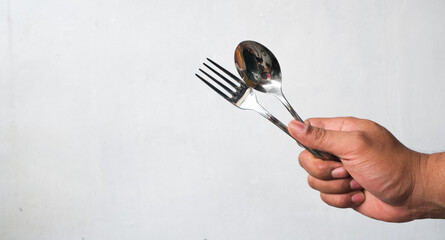 portrait of man's hand holding spoon and fork isolated on white background