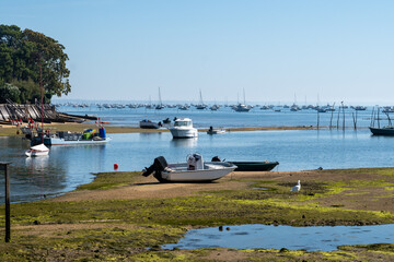 Obraz premium View on Arcachon Bay at low tide with many fisherman's boats and oysters farms, Cap Ferret peninsula, France, southwest of Bordeaux along France's Atlantic coastline