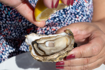 Eating of fresh live oysters at farm cafe in oyster-farming village, Arcachon bay, Cap Ferret...
