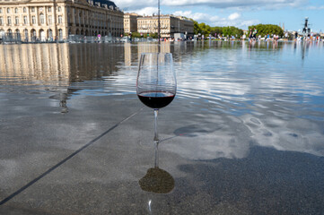 Tasting of Bordeaux blended red wine with wine city Bordeaux on background, left bank of Gironde...