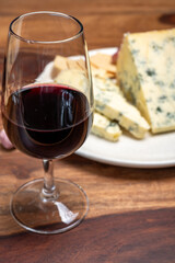 Red porto and cheese pairing, blue matured stilton English cheese served as dessert with walnuts and glass ruby porto wine